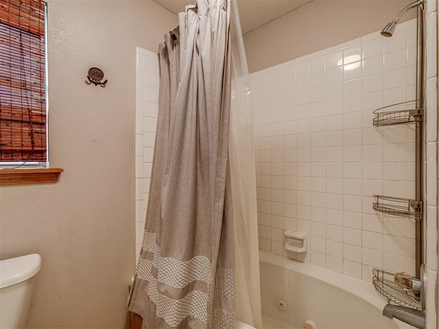 full bathroom featuring toilet and a combined bath / shower with jetted tub