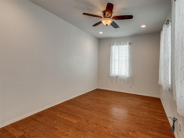 empty room featuring ceiling fan, wood finished floors, and baseboards