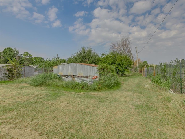 view of yard with fence and an outdoor structure