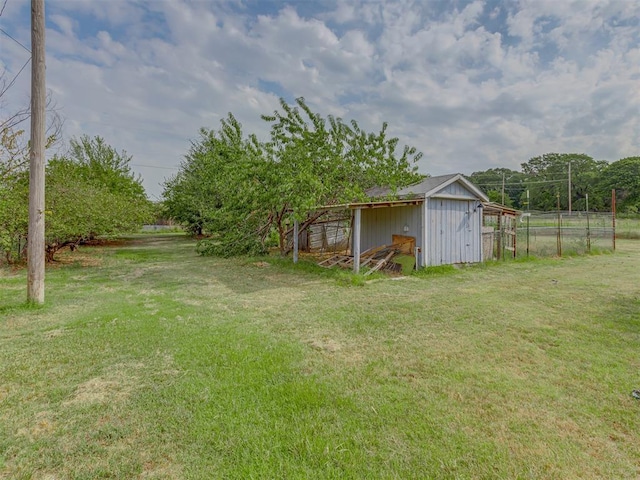 view of yard with fence and an outbuilding