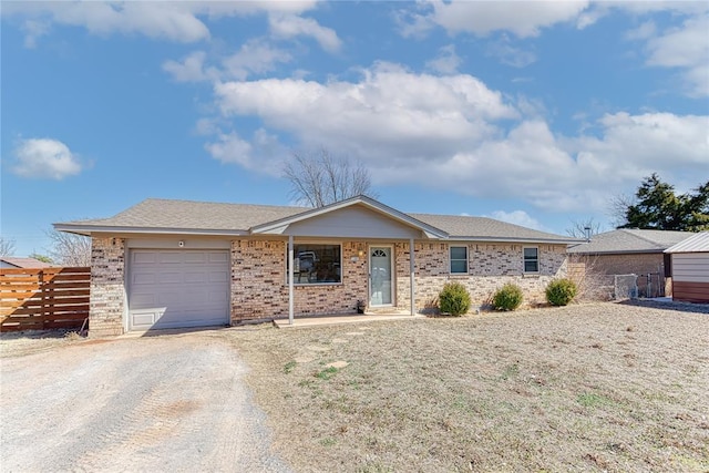 ranch-style home with a garage, brick siding, fence, and driveway