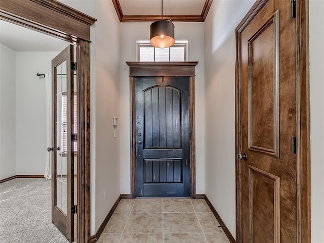 foyer with ornamental molding, baseboards, and light tile patterned floors