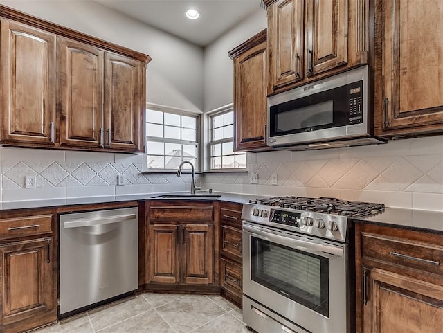 kitchen with stainless steel appliances, a sink, and tasteful backsplash