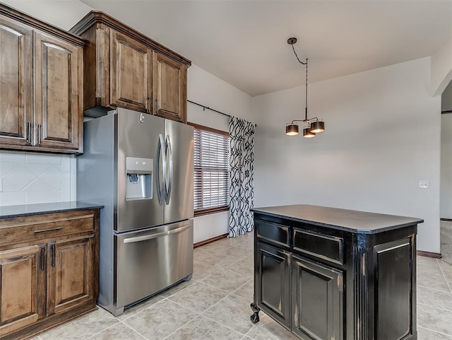 kitchen with dark countertops, tasteful backsplash, stainless steel refrigerator with ice dispenser, and light tile patterned flooring