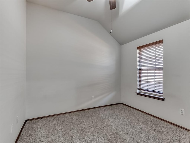 spare room featuring vaulted ceiling, carpet flooring, a ceiling fan, and baseboards