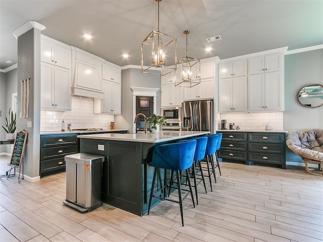 kitchen with crown molding, stainless steel fridge, white cabinets, and built in microwave