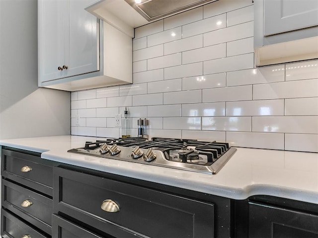 kitchen featuring stainless steel gas cooktop, light countertops, and backsplash