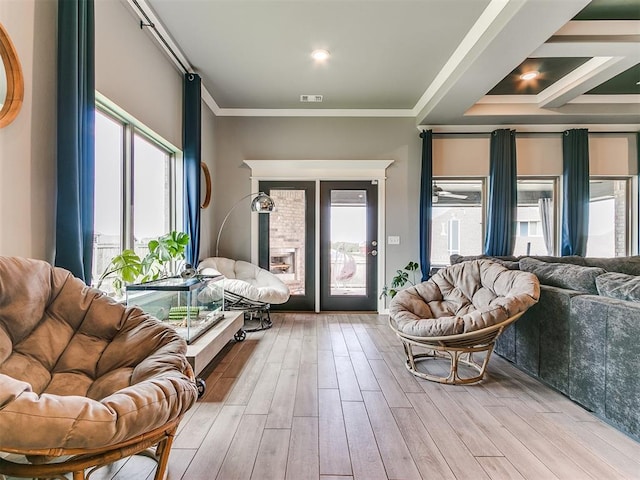 interior space featuring ornamental molding, wood finished floors, visible vents, and a healthy amount of sunlight