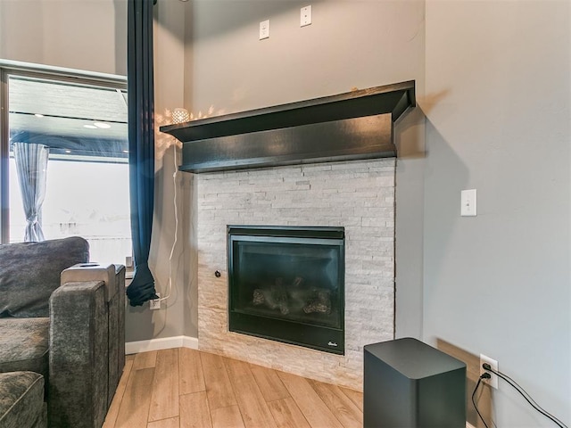 room details with a fireplace, baseboards, and wood finished floors