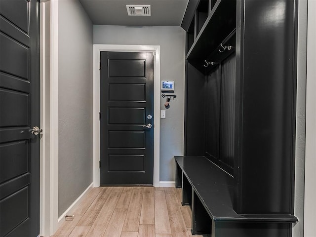 mudroom with light wood-type flooring, visible vents, and baseboards