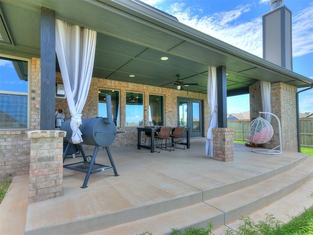 view of patio / terrace with fence, a ceiling fan, and outdoor dining space