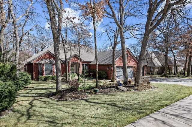 view of front of house with a front yard, brick siding, driveway, and an attached garage