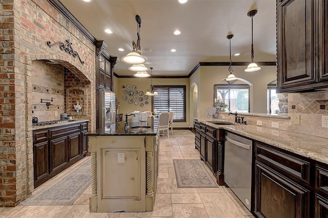 kitchen with crown molding, stone tile floors, light stone countertops, and stainless steel appliances