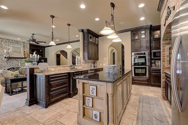 kitchen with dark brown cabinets, arched walkways, tasteful backsplash, and appliances with stainless steel finishes