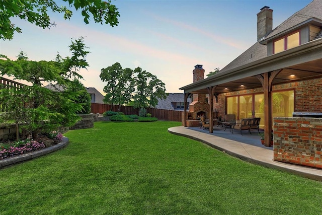 yard at dusk featuring a fenced backyard and a patio