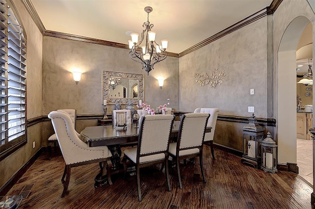 dining room featuring an inviting chandelier, wood finished floors, arched walkways, and ornamental molding