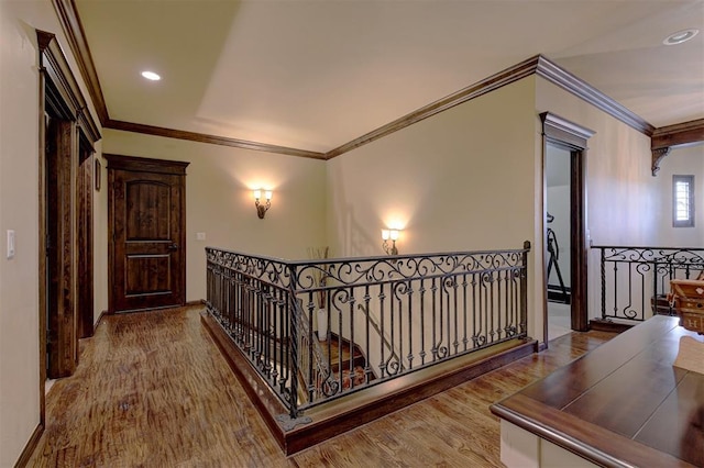 corridor featuring an upstairs landing, recessed lighting, crown molding, and wood finished floors