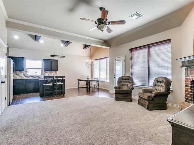 interior space with a brick fireplace, plenty of natural light, visible vents, and dark colored carpet