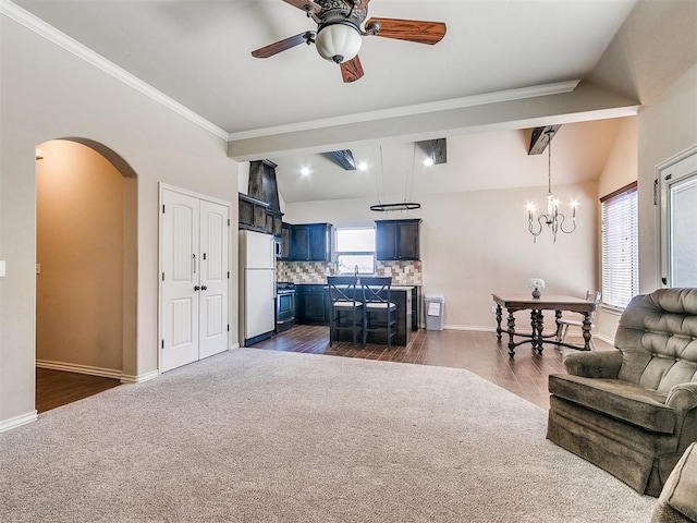 living room featuring arched walkways, vaulted ceiling, and baseboards