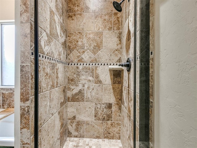 interior details featuring a textured wall and a shower stall