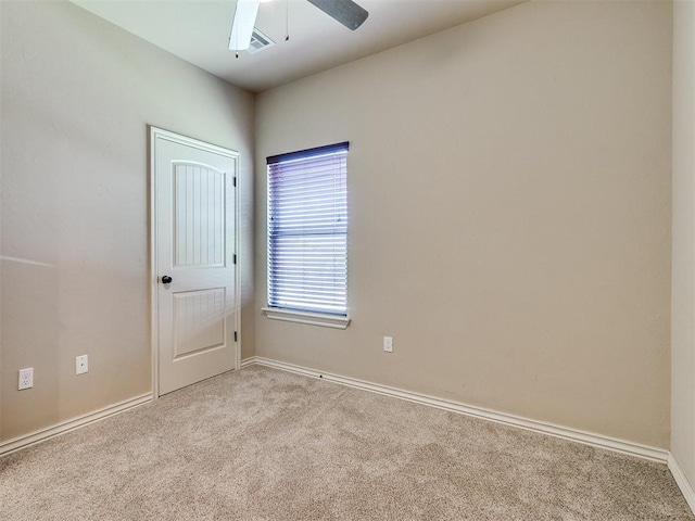 unfurnished room featuring light carpet, baseboards, and a ceiling fan