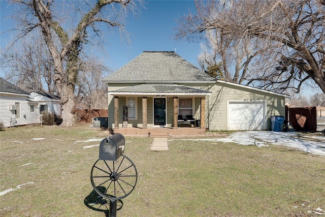 bungalow-style house with roof with shingles, covered porch, an attached garage, driveway, and a front lawn