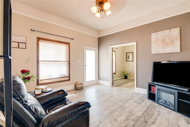 living area with light wood-style flooring, baseboards, and a ceiling fan