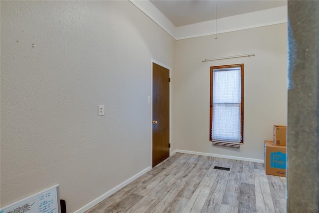 interior space with baseboards, visible vents, and light wood finished floors