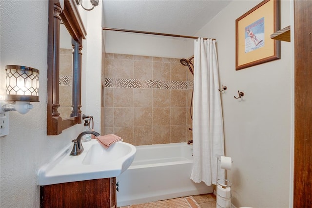 bathroom with a textured ceiling, shower / bath combo, and vanity