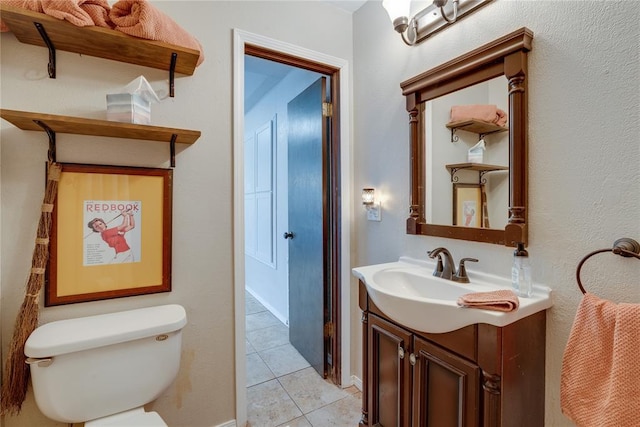 half bathroom featuring tile patterned flooring, vanity, and toilet