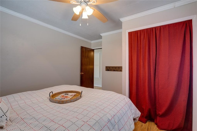 bedroom with ornamental molding, a ceiling fan, and wood finished floors