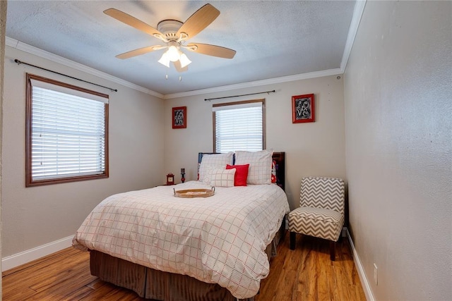 bedroom featuring baseboards, ceiling fan, ornamental molding, wood finished floors, and a textured ceiling