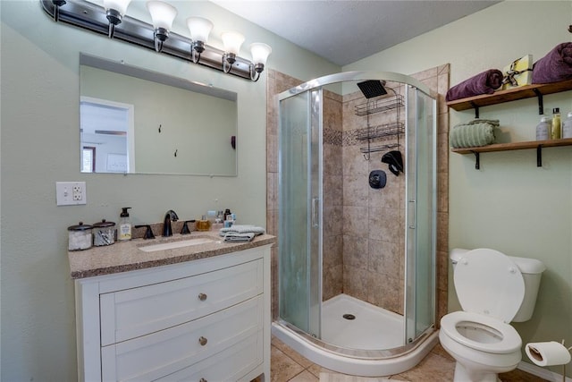 bathroom with toilet, a shower stall, tile patterned flooring, and vanity