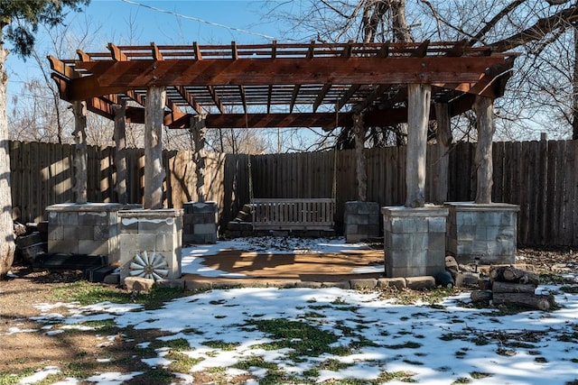 snow covered patio with fence and a pergola