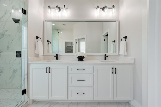 bathroom with marble look tiles, a marble finish shower, and double vanity