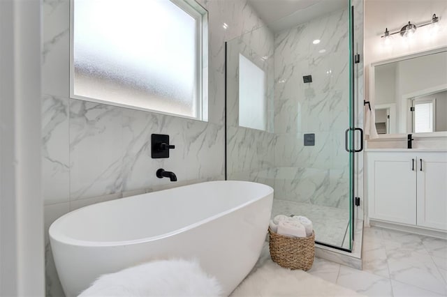 full bath with marble finish floors, a marble finish shower, a freestanding tub, and vanity