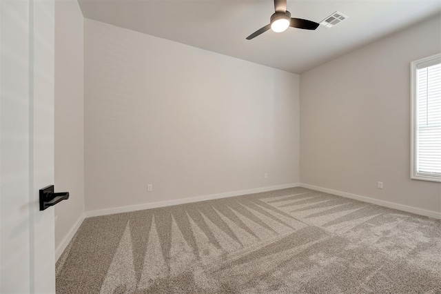 carpeted empty room with a ceiling fan, plenty of natural light, and baseboards
