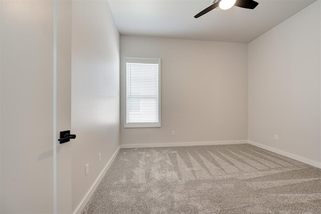 carpeted empty room with ceiling fan and baseboards