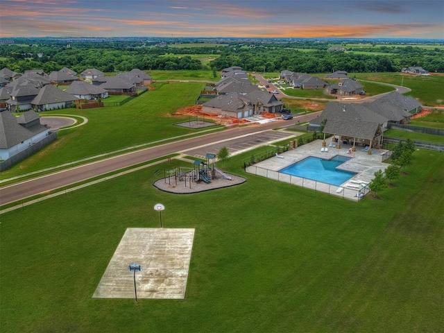 aerial view at dusk of view of pool area and a residential view