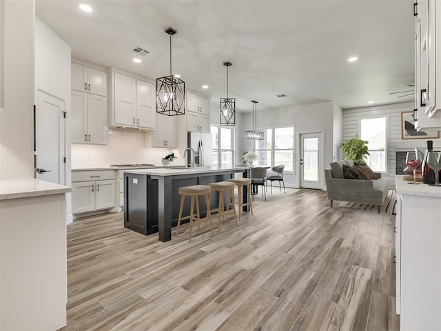 7112 NW 154th St, Edmond, OK 73013 - kitchen with white cabinetry, recessed lighting, backsplash, stovetop, and a breakfast bar area