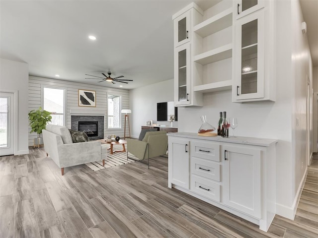 7112 NW 154th St, Edmond, OK 73013 - living area featuring ceiling fan, light wood-style flooring, baseboards, a glass covered fireplace, and recessed lighting