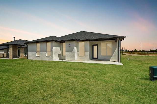 7112 NW 154th St, Edmond, OK 73013 - back of house featuring a patio, a yard, and brick siding