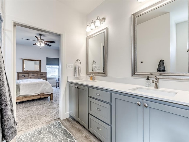 bathroom featuring a ceiling fan, double vanity, a sink, and ensuite bathroom