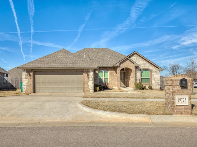 french country inspired facade with driveway, a shingled roof, a garage, and brick siding