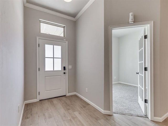 foyer entrance featuring ornamental molding, baseboards, and light wood finished floors