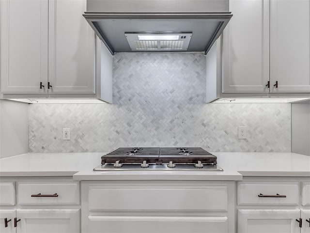 kitchen featuring white cabinets, custom range hood, stainless steel gas cooktop, and light countertops