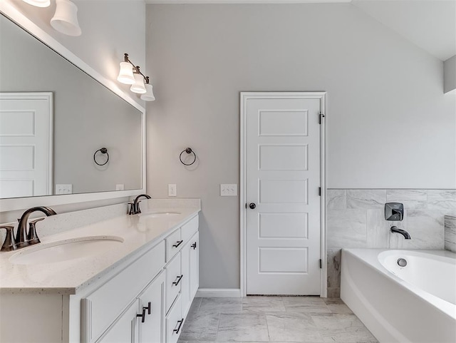 full bath featuring vaulted ceiling, marble finish floor, a sink, and double vanity