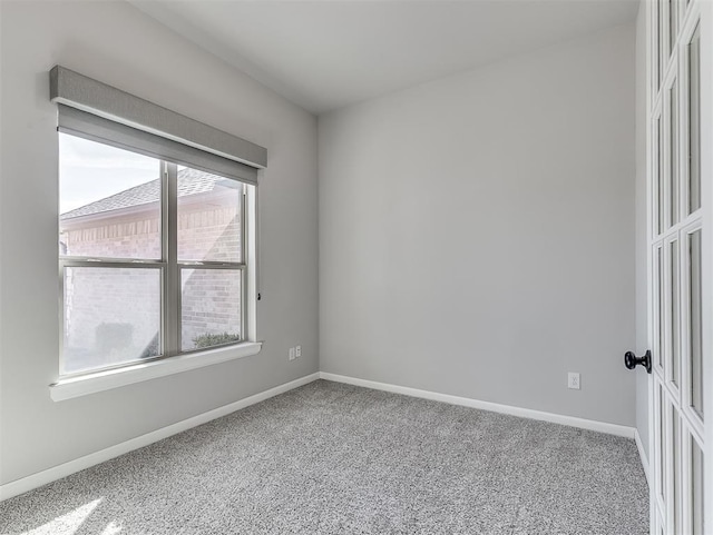 carpeted spare room with baseboards
