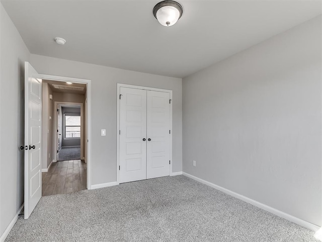 unfurnished bedroom with carpet floors, baseboards, and a closet