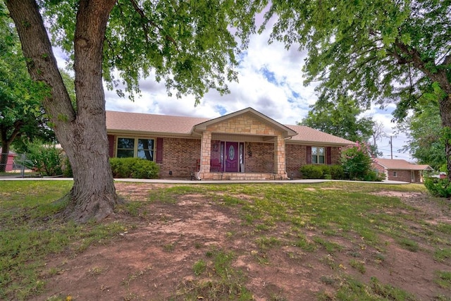 single story home featuring brick siding and a front lawn